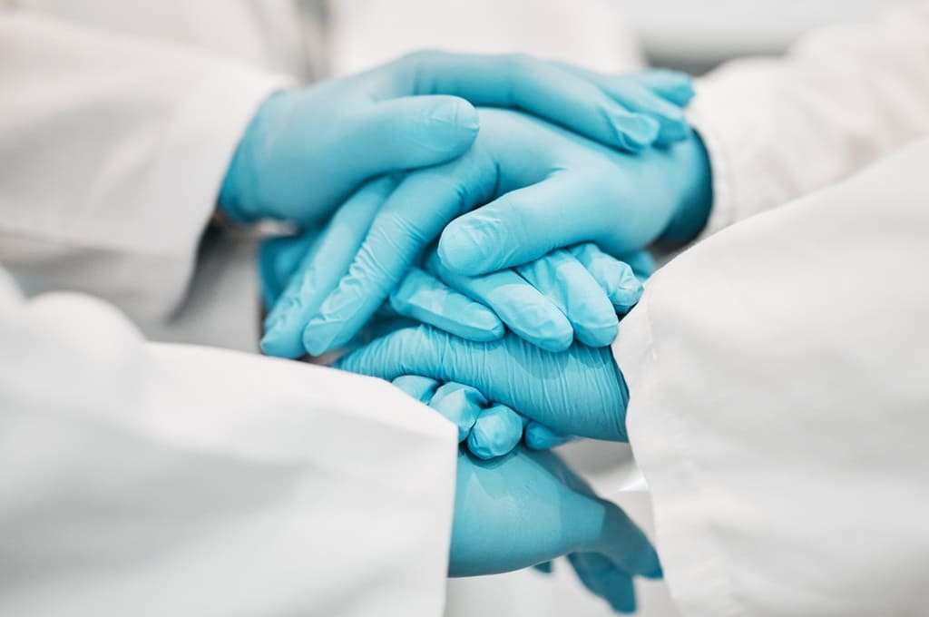 profissionais de saúde_ENVATO_Por YuriArcursPeopleimages_ppe-doctor-and-nurse-hands-together-for-teamwork-2023-09-13-19-01-12-utc
