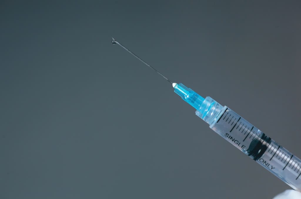 vacina_Por Garakta-Studio_ENVATO_HN_syringe-with-vaccine-droplet-on-the-needle-2023-11-27-05-12-41-utc
