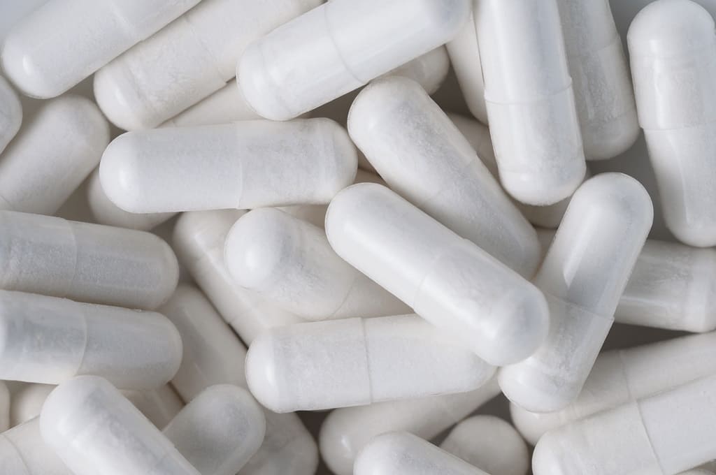 medicamentos_Por serenkonata_ENVATO_HN_top-view-closeup-pile-of-white-antibiotic-capsule-2023-11-27-05-21-21-utc
