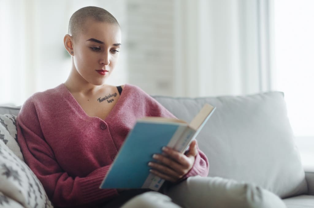 cancro_Por halfpoint_ENVATO_HN_young-woman-with-cancer-reading-book-cancer-aware-2023-11-27-05-23-52-utc