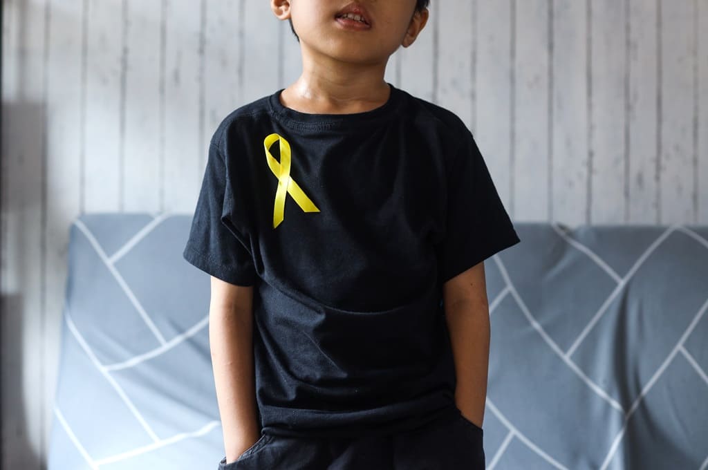 cancro_Por Garakta-Studio_ENVATO_HN_boy-with-golden-yellow-ribbon-world-childhood-can-2023-11-27-05-21-01-utc