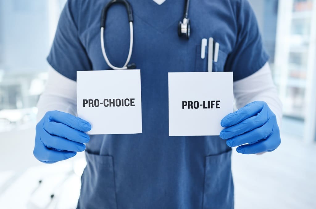 aborto_Por YuriArcursPeopleimages_ENVATO_HN_closeup-doctor-and-abortion-with-option-card-and-2023-11-27-04-58-53-utc