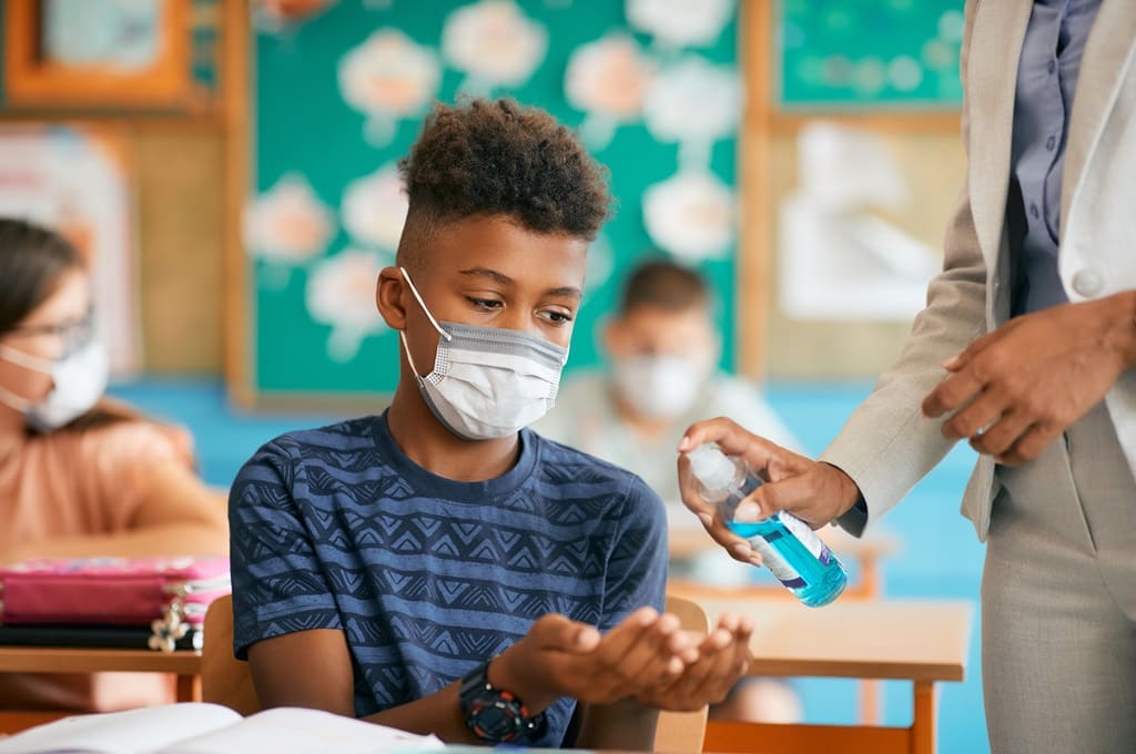 covid-19_Por drazenphoto_ENVATO_HN_black-schoolboy-wearing-face-mask-and-disinfecting-2023-11-27-05-31-52-utc