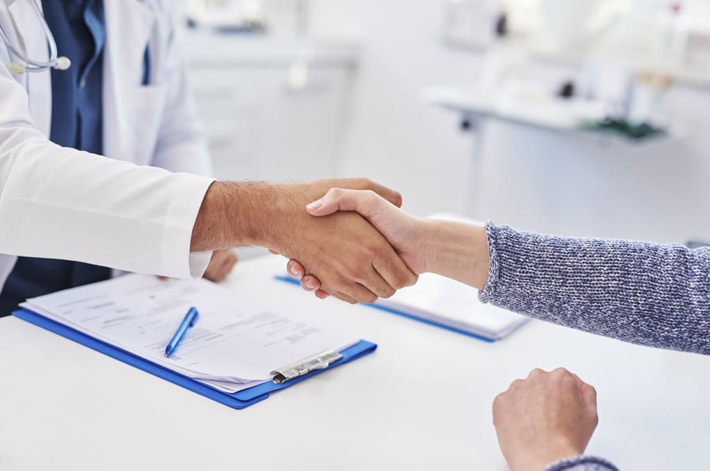 médicos_Por gpointstudio_ENVATO_HN_detail-of-handshake-of-doctor-and-patient-in-docto-2023-11-27-05-34-59-utc